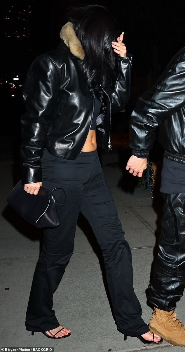 The beauty seemed unusually shy as she put a well-manicured hand over her face while looking down; she also put her tummy on display