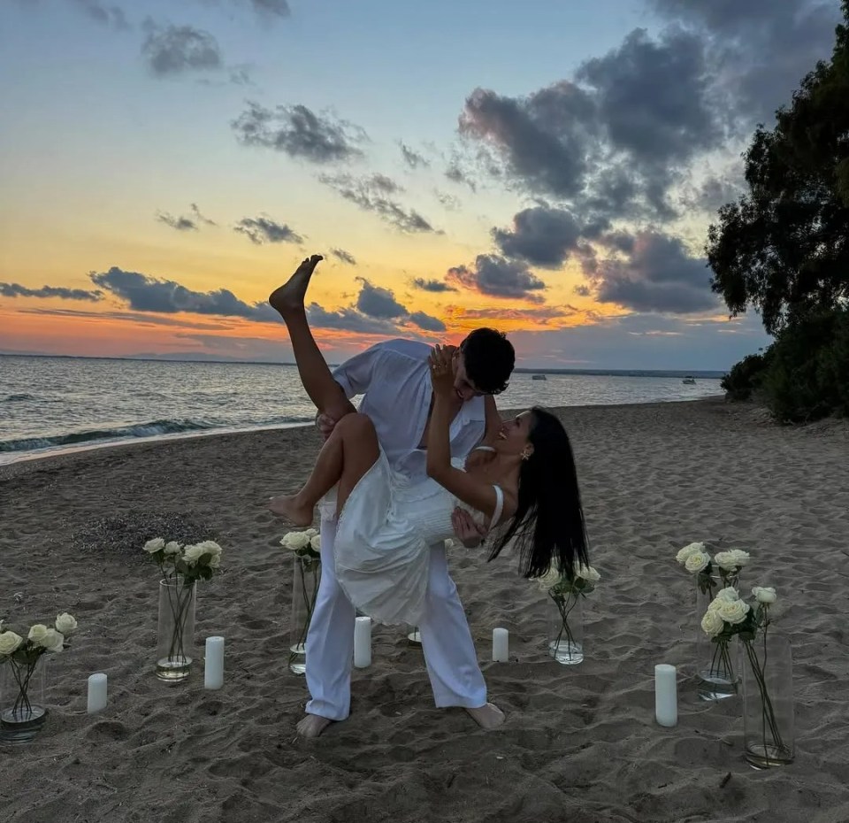 Emily Miller and Cam Holmes announcing engagement on a beach at sunset.