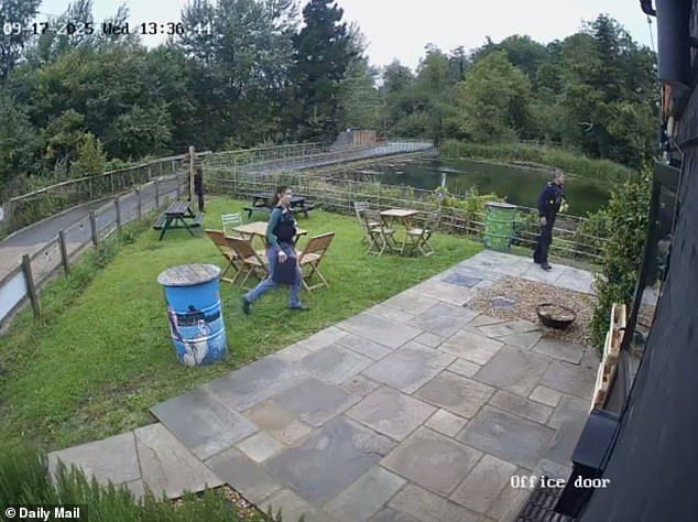 Officers can be seen in CCTV footage stooping beneath a wooden rail fence, as others surround the building