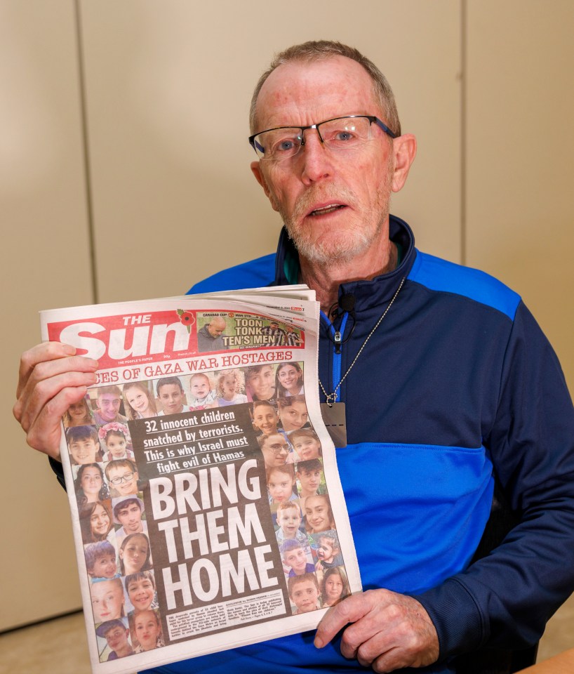 Tom Hand holding a copy of The Sun newspaper with the headline "Bring Them Home" and photos of child hostages.