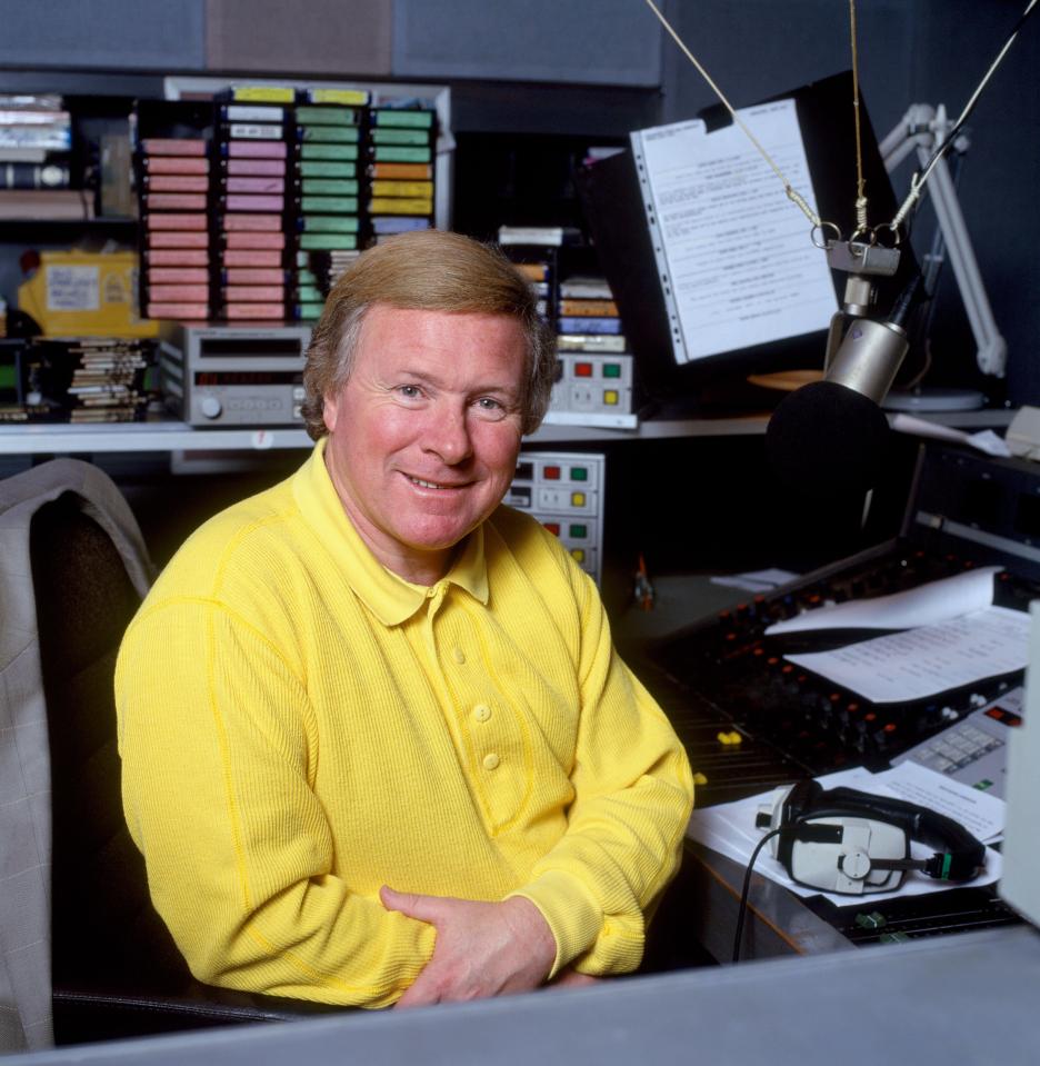 a man in a yellow shirt sits in front of a microphone