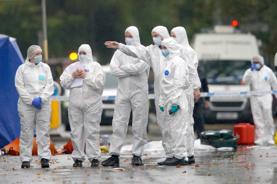 Forensic teams investigate a stabbing incident in Manchester, England.