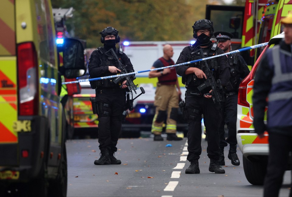 Armed police officers and emergency personnel at the scene of an attack in north Manchester.