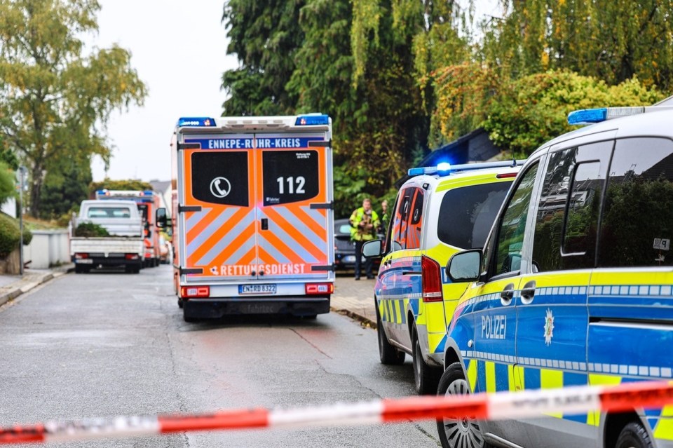 Ambulance and police cars parked on a street in Herdecke, Germany.