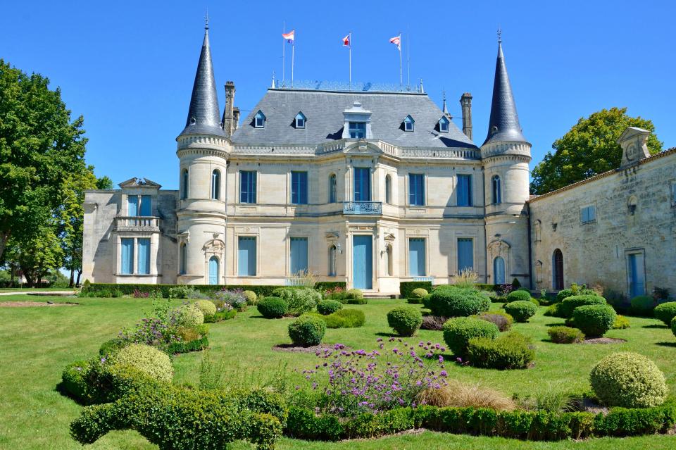 Château Palmer, a wine-producing estate in France's Bordeaux region, with a formal garden in the foreground.