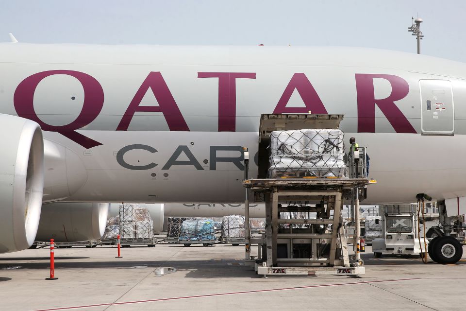 A worker offloading cargo from a Qatar Airways Cargo plane.