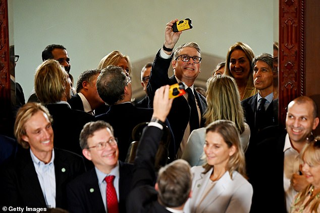 Starmer takes a selfie with a disposable camera during an interaction with the business leaders