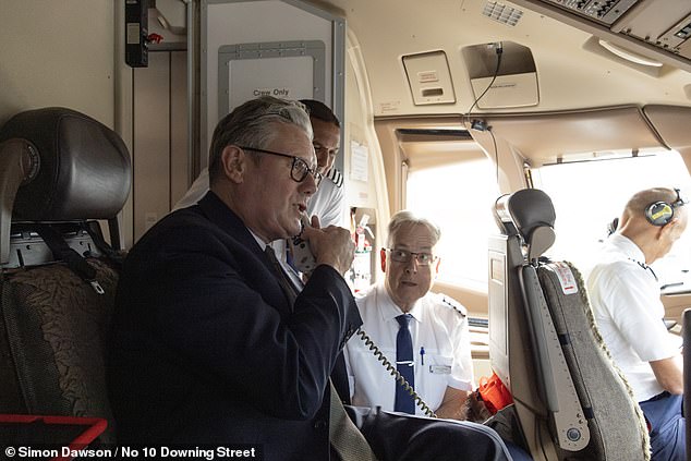 Keir Starmer speaks on the tannoy system to passengers on the plane as he prepares to board a flight to India where he will meet Narendra Modi