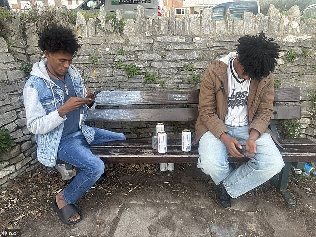 Asylum seekers from Eritrea are seen drinking cans of Stella Artois while overlooking the sea view