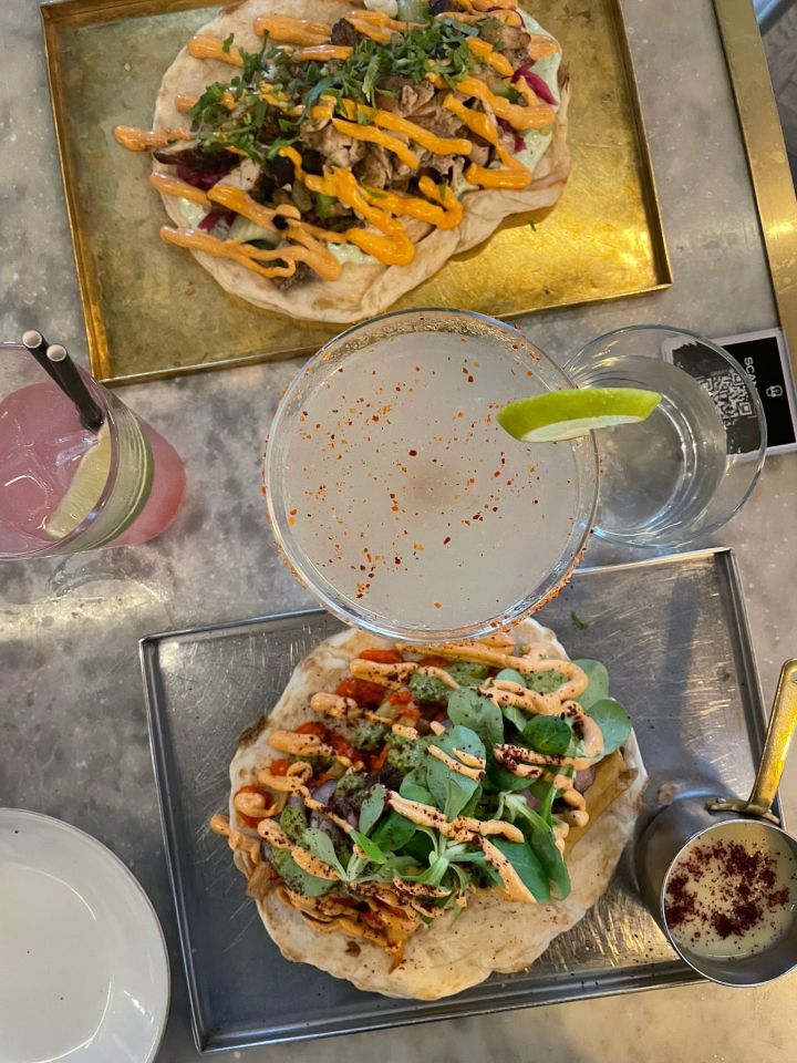 Two kebabs with drinks on a marble table.