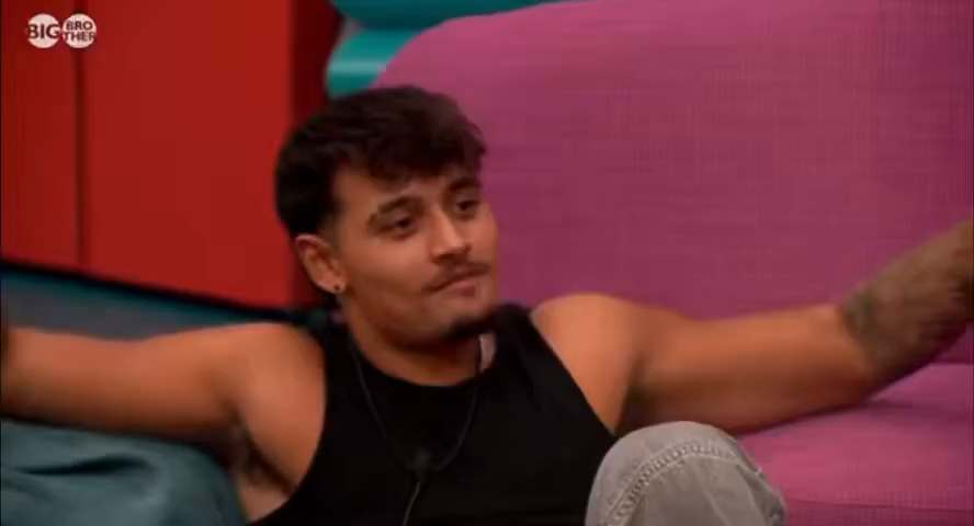 Big Brother contestant Zelah sitting with arms outstretched, looking to the side.