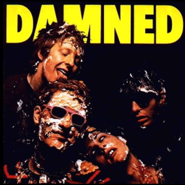 Cover art for The Damned's album, "Damned," featuring four band members covered in cake.