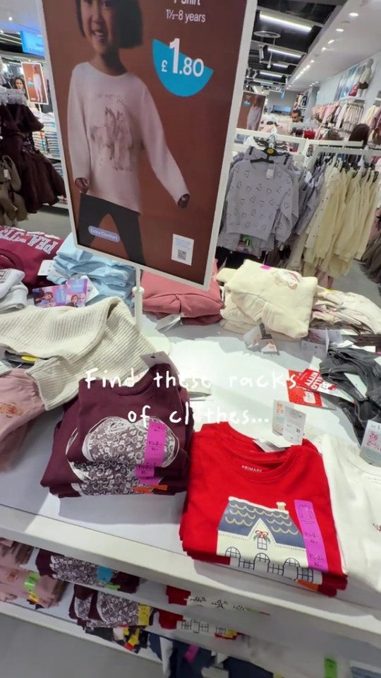 A children's clothing display in a store, with a sign advertising a £1.80 t-shirt.