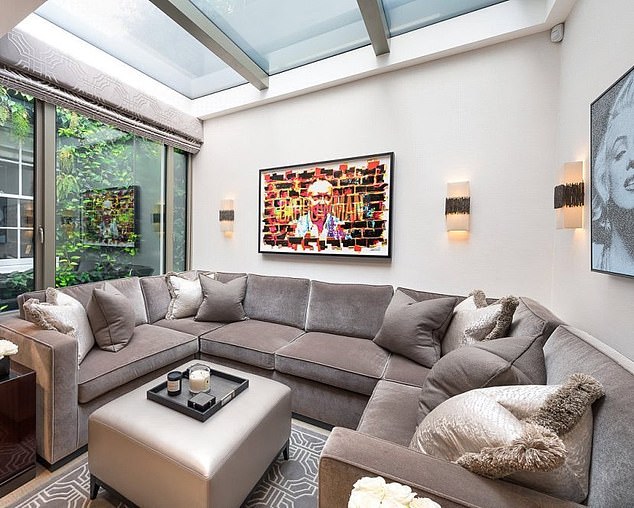 The Belgravia home's living room had original artwork on the wall depicting Lady Mone's husband Doug Barrowman (centre) above the sofa next to an image of one of her heroines, Marilyn Monroe (far right)