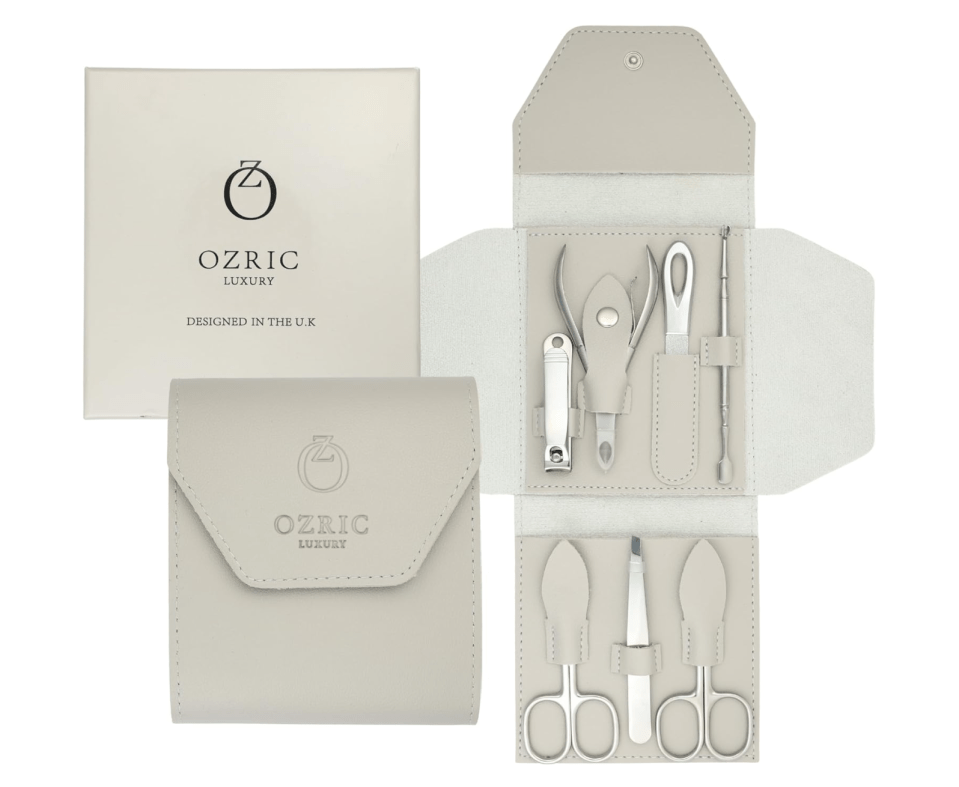 Ozric Luxury manicure set in a light grey leather-like case, displayed open with various silver tools, next to its packaging.