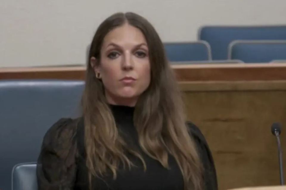 Alexis Von Yates, with long brown hair, sitting in a courtroom.