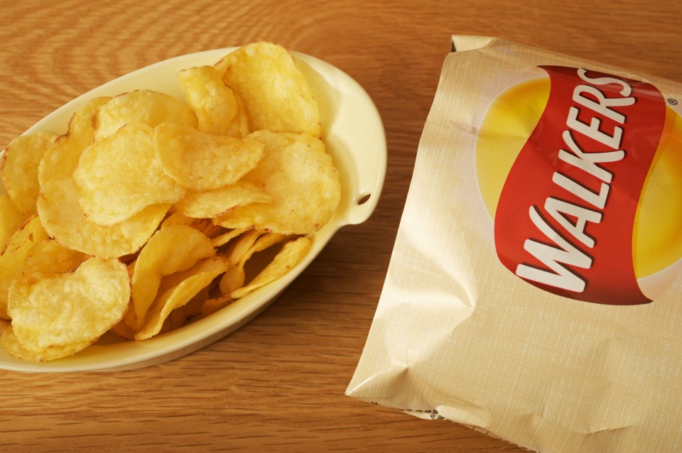 Walkers crisps in a bowl next to a Walkers crisps bag.