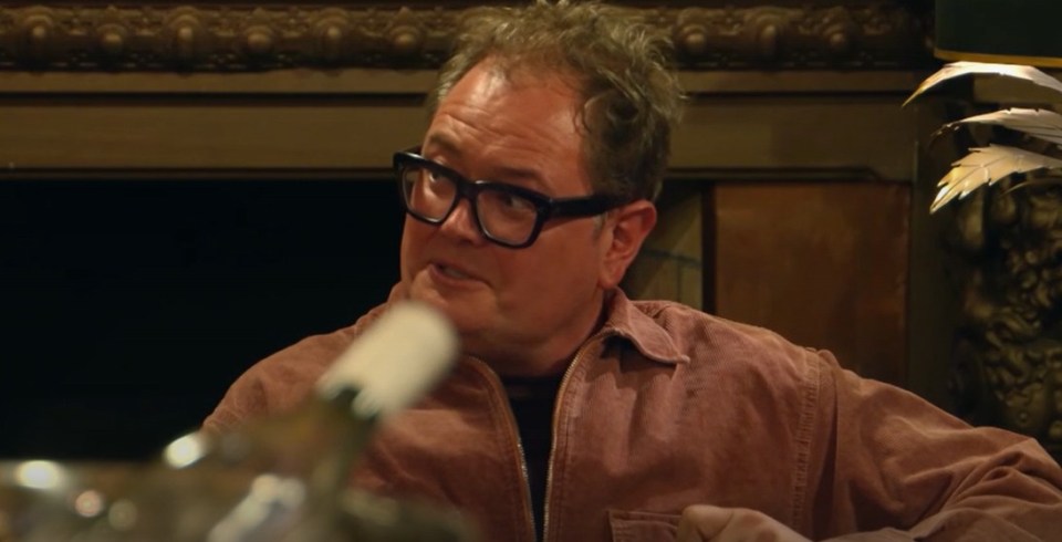 Man with glasses in a pink jacket.