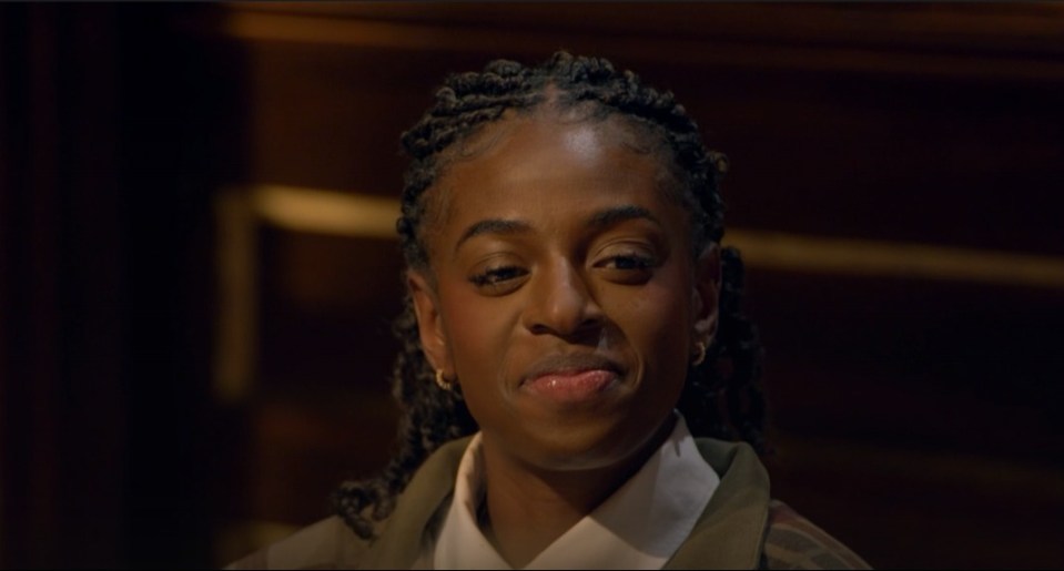 A young woman with braided hair and a white collared shirt smiles.