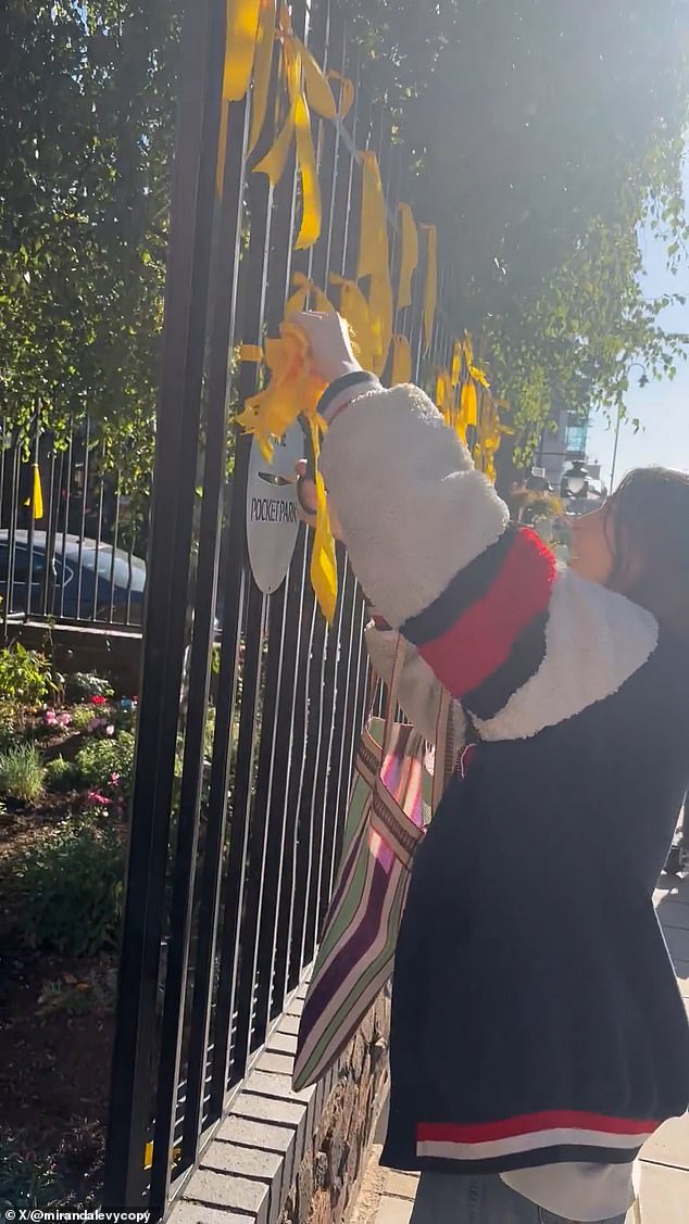 She cuts down ribbons for Israeli hostages from a fence in Muswell Hill, North London
