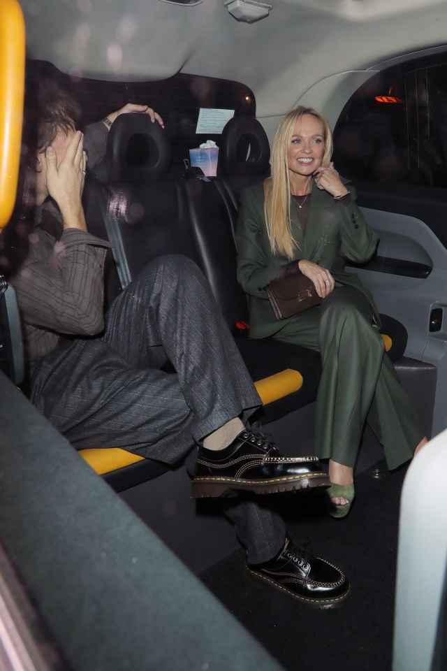 Emma Bunton sitting in a taxi with a person covering their face.