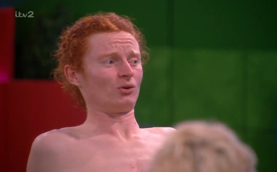 Shirtless George from Big Brother with red hair, looking surprised.