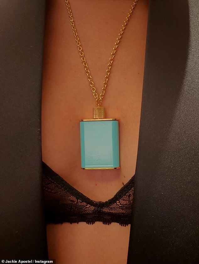 Jackie showed off her racy look, consisting of a black lace bra underneath a black blazer with a statement blue perfume bottle necklace