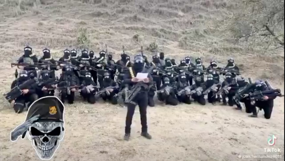Armed members of the Jalisco New Generation Cartel in a field, with one member standing and reading from paper, and an added skull graphic.