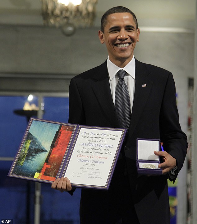 President and Nobel Peace Prize laureate Barack Obama poses with his medal and diploma at the Nobel Peace Prize ceremony at City Hall in Oslo, Thursday, December 10, 2009