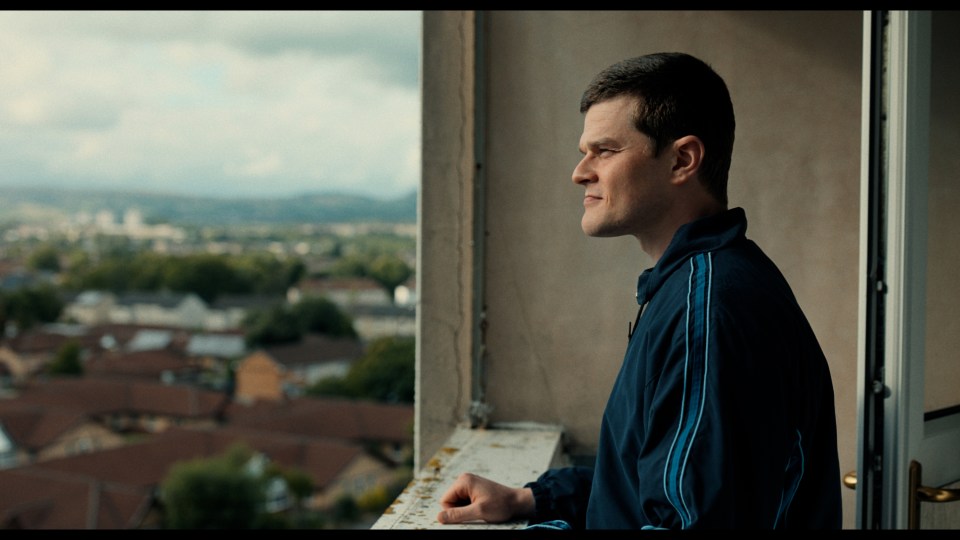 Robert Aramayo as John Davidson looking out over a city.