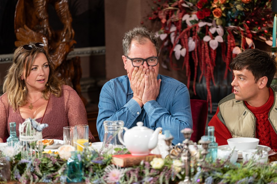 A woman, a man, and a young man seated at a table decorated with flowers and dishes.