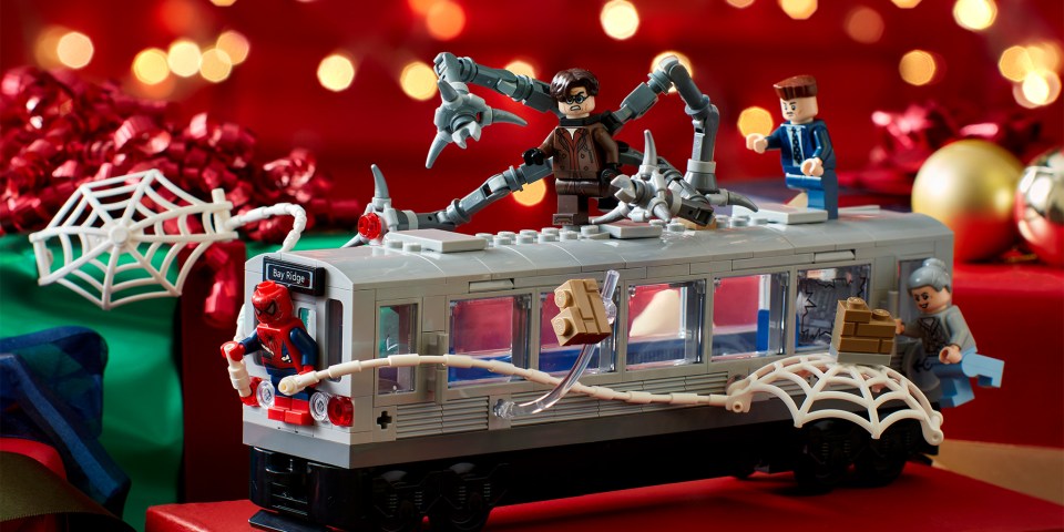 Lego subway car from the Spider-Man movie on a red background with festive lights.