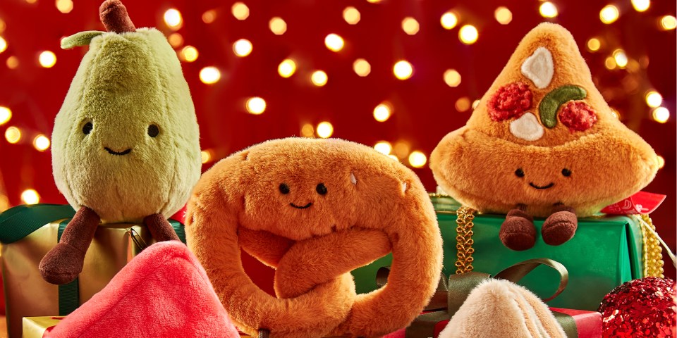 Three Christmas plush toys that resemble a pear, a pretzel, and a slice of pizza.