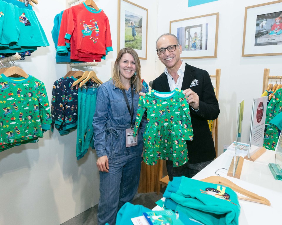 Sally Dear and Theo Paphitis at the Ducky Zebra booth with colorful children's clothing.