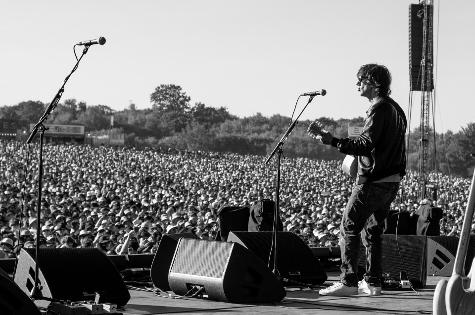 Richard Ashcroft performs on stage to a large crowd.