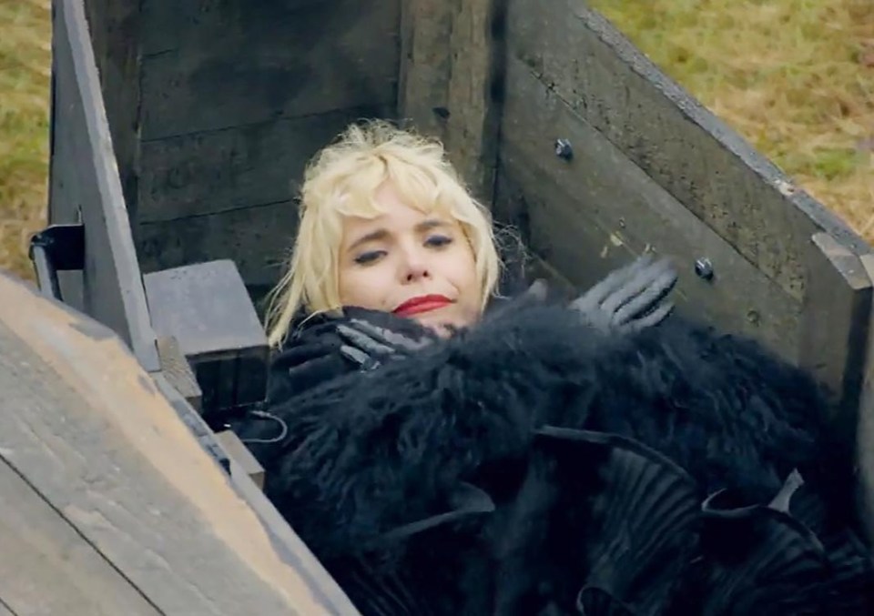 Paloma Faith lying inside a coffin during a Celebrity Traitors funeral.