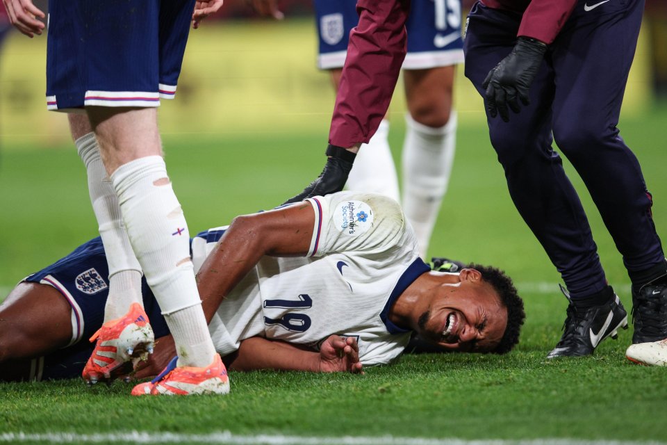 Ollie Watkins of England grimacing in pain while lying on the grass with an injury.