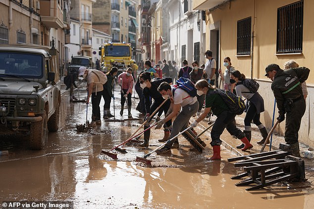 The warning comes nearly a year after widespread flooding in Valencia killed more than 200 people. Pictured: People work to clear mud and debris from a street in Aldaia, Valencia on November 5, 2024