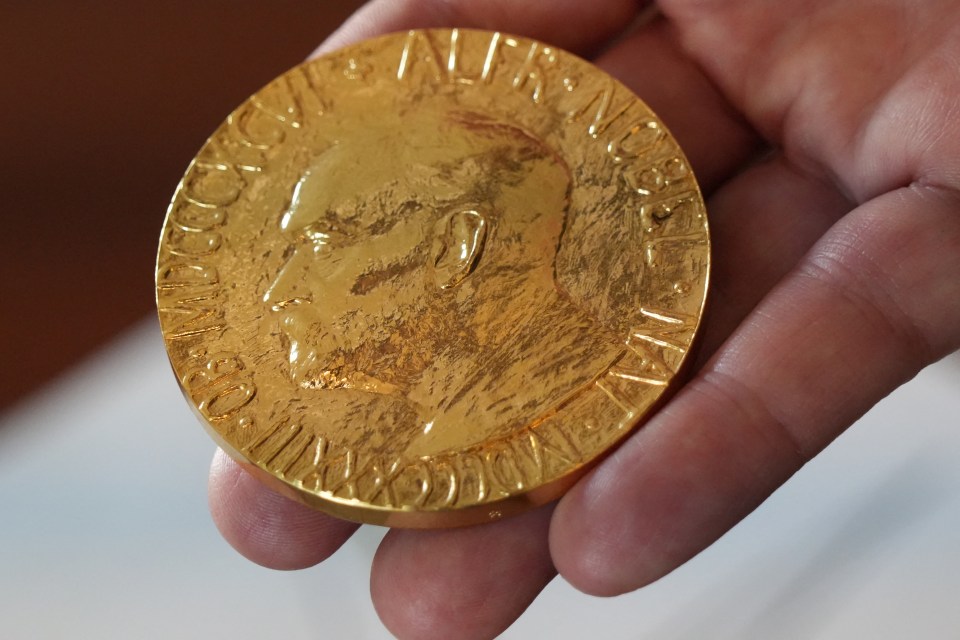 An employee of the Norwegian Nobel Institute holds a replica of a Nobel Peace Medal in the Institute in Oslo