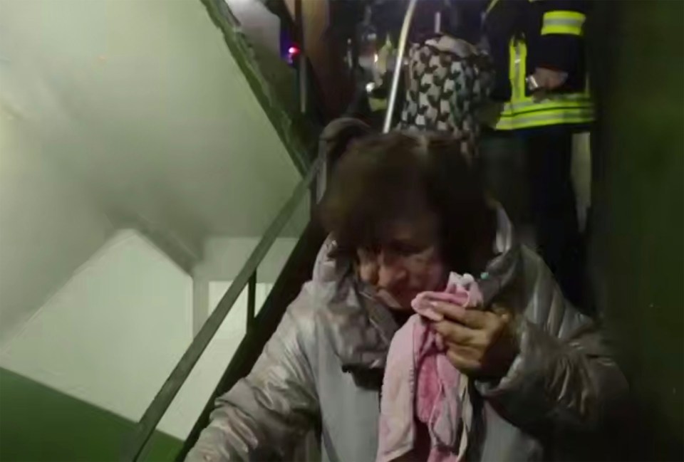 An elderly woman is being evacuated from a block of flats in Kyiv after a Russian attack.