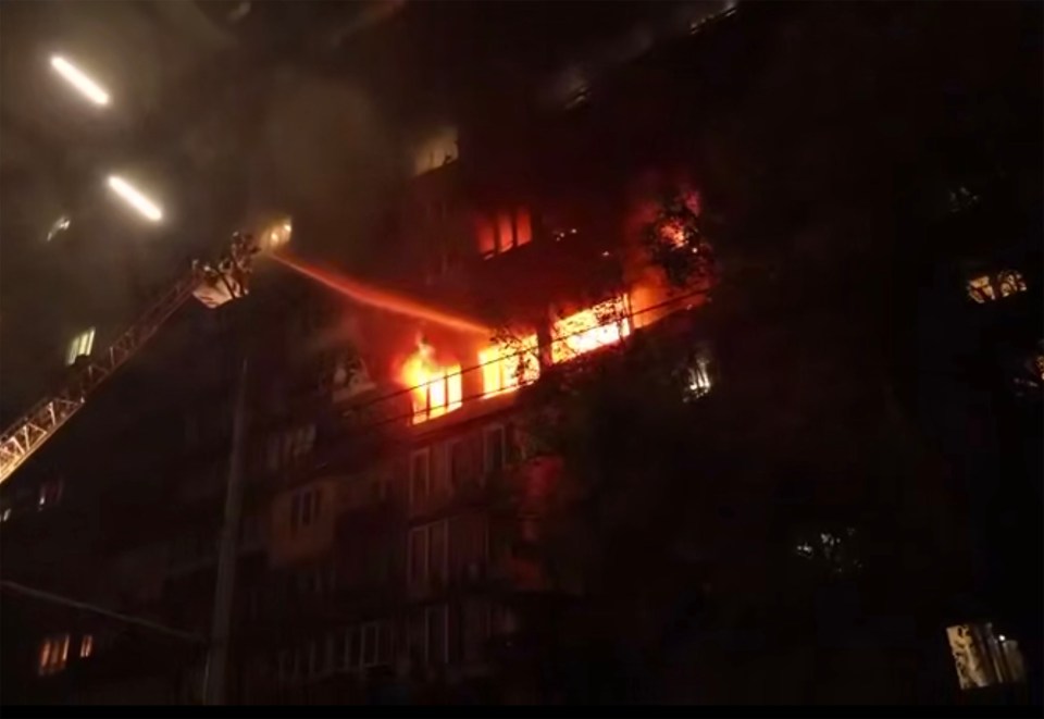 Firefighters douse a burning building with water.