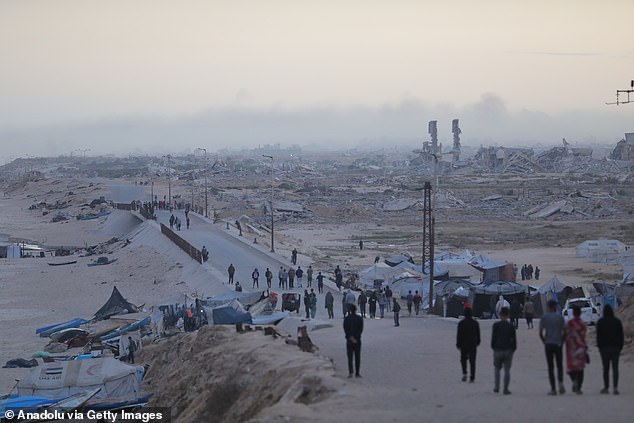 Some Palestinians walk on foot along Rashid Street, carrying the few belongings they manage to save, as they hope to go back to their homes after enduring harsh living conditions for months in Gaza City