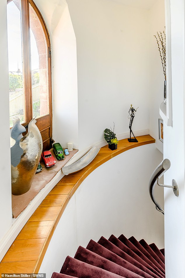 Prospective buyers need only head up the property's carpeted spiral staircase (pictured) and out its battery-operated roof hatch to appreciate its stunning aspect