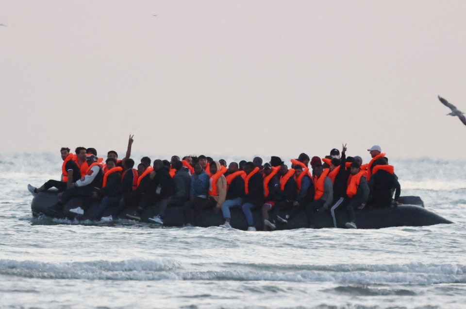 Migrants in an inflatable boat at sea.