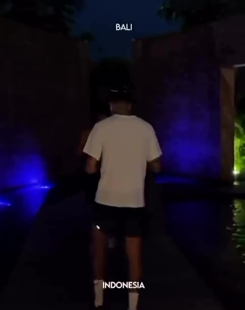 A person walking away from the camera at night in Bali, Indonesia.