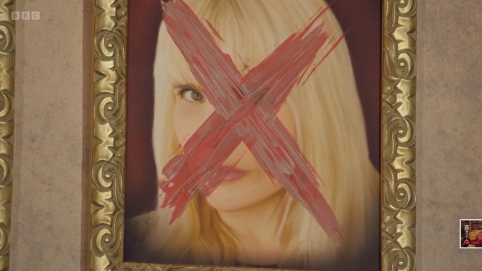 A framed portrait of a blonde woman with a red X painted over her face.