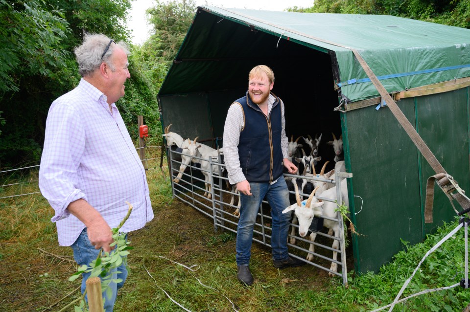 Jeremy Clarkson and Kaleb Cooper by an enclosure of goats.