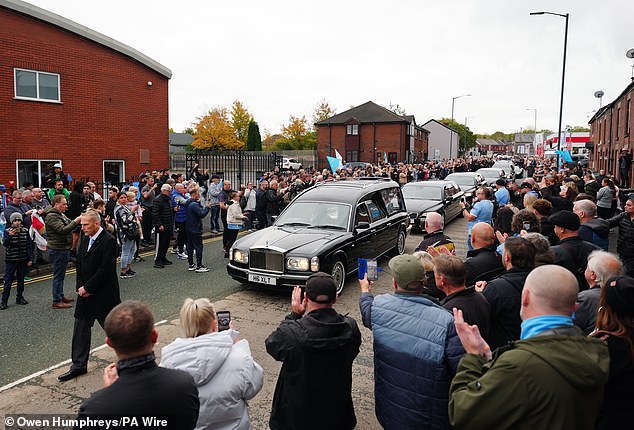 The cortege stops outside Hatton's Gym in Hyde during the procession this morning