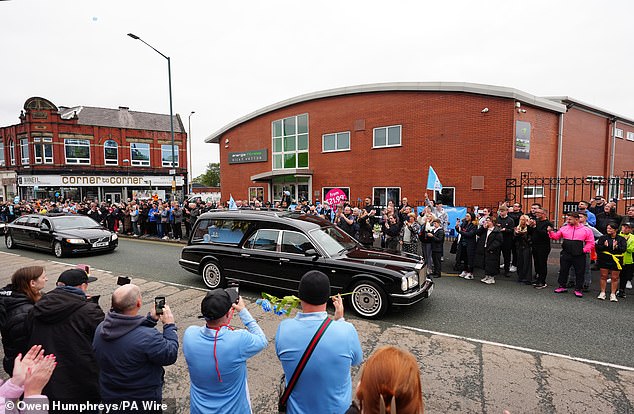 The cortege stops outside Hatton's Gym in Hyde during the procession this morning
