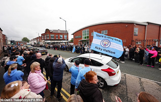 Mourners outside Hatton's Gym in Hyde during the procession this morning